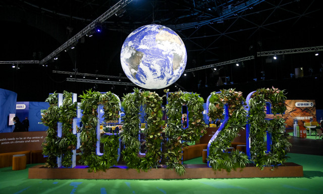 The COP26 Globe at the Hydro. In the foreground, plants form the text #COP26