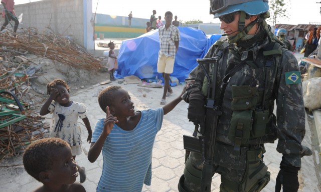 A peacekeeper supervises children in Haiti