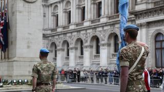 UN peacekeepers day ceremony at the cenotaph in Whitehall, London. UN Peacekeeping troops stand facing the cenotaph which has wreaths laid on it