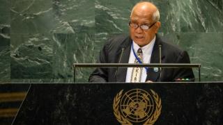 Ambassador Tito stands behind a lectern with the UN logo to address the 79th session of the UN General Assembly